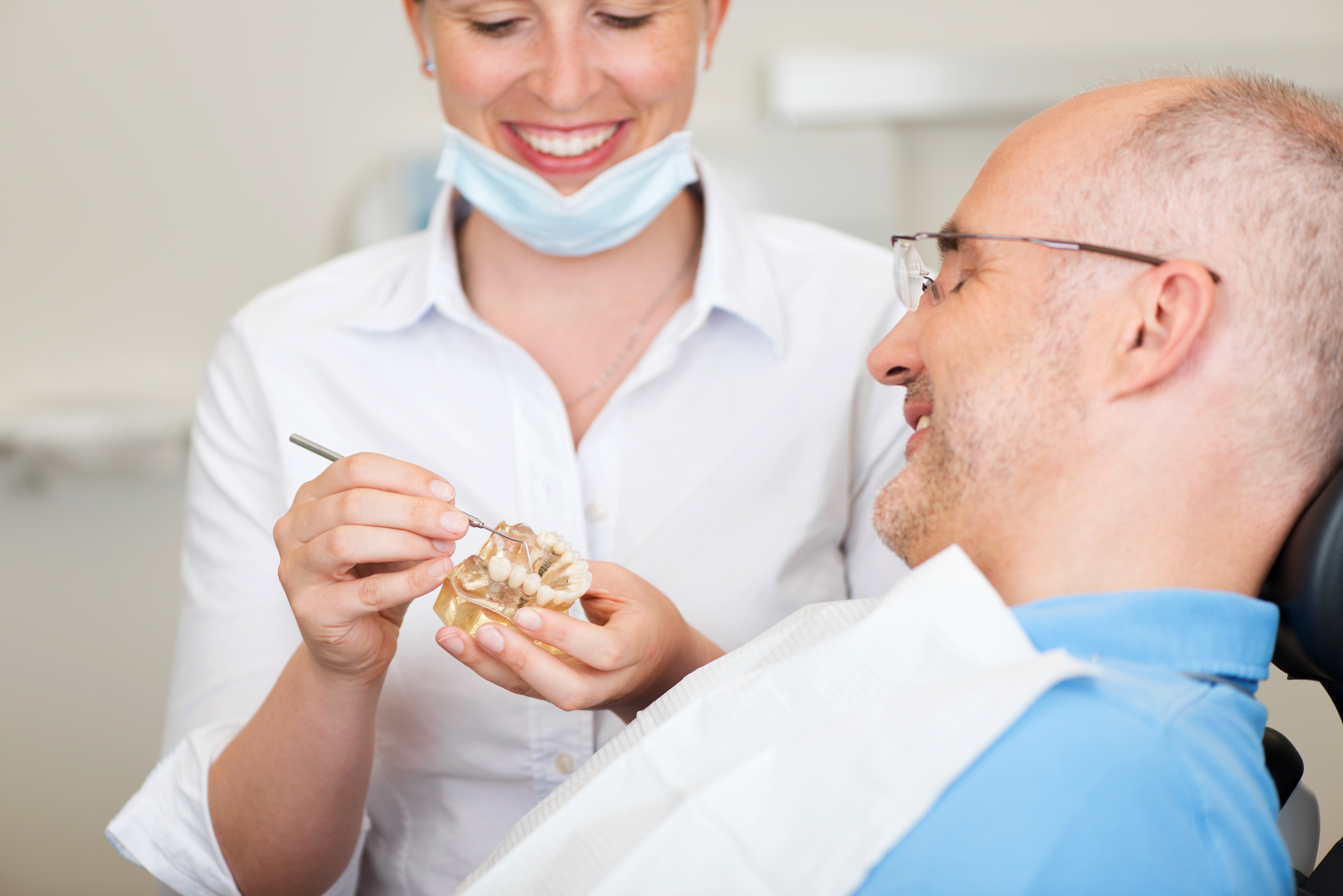 Dentist tinkering with a dental mould in front of a patient